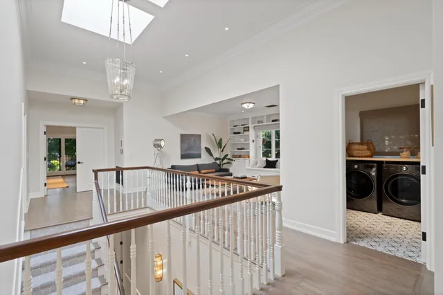 a bedroom with a bed a chair and potted plant on the dresser