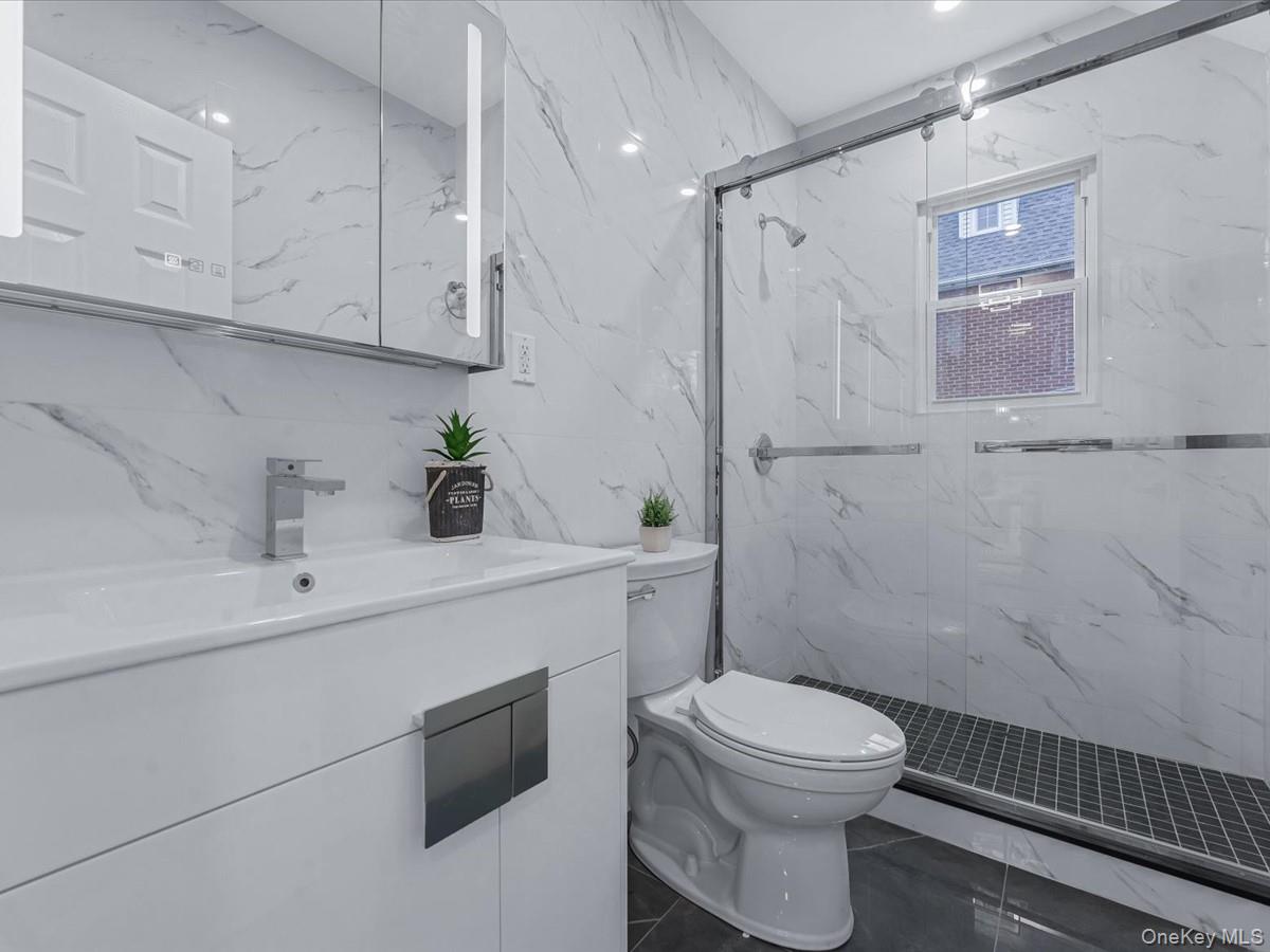 62 Essex Road Great Neck, NY 11023 - Photo 14 of 25 a bathroom with a sink a toilet and shower