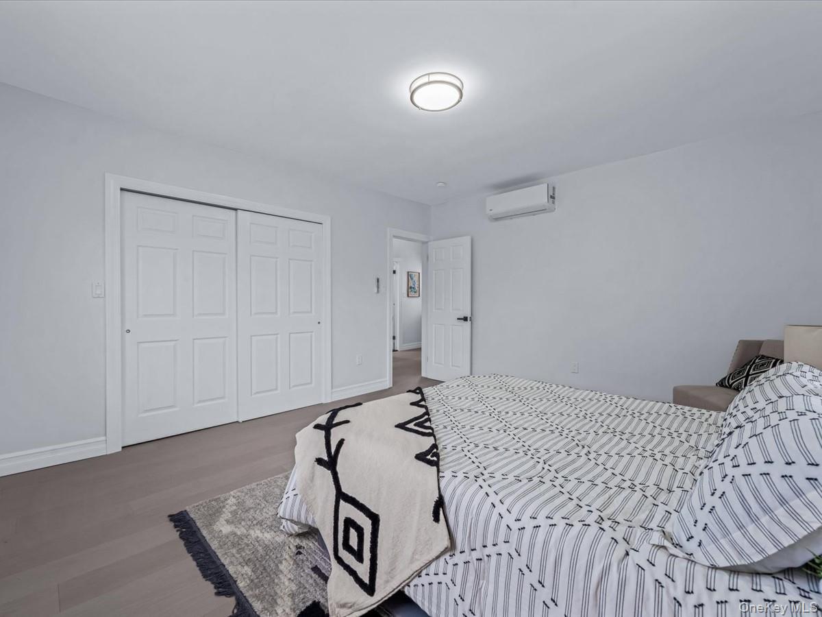 62 Essex Road Great Neck, NY 11023 - Photo 16 of 25 a bedroom with a bed and wooden floor