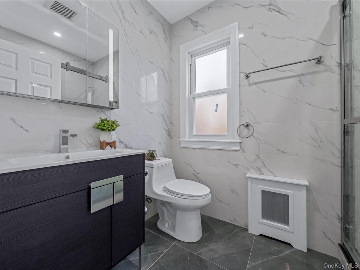 62 Essex Road Great Neck, NY 11023 - Photo 19 of 25 a bathroom with a sink toilet and vanity