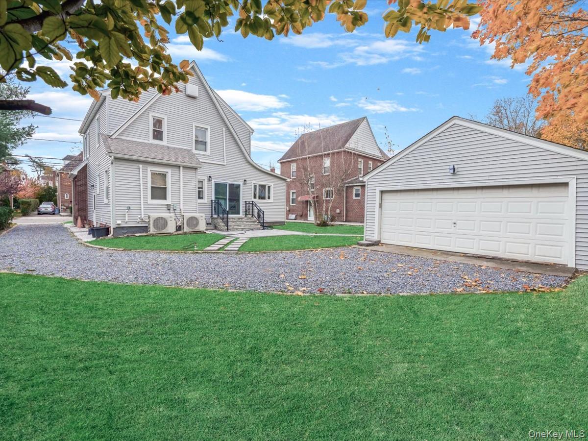 62 Essex Road Great Neck, NY 11023 - Photo 23 of 25 a front view of a house with a garden and plants