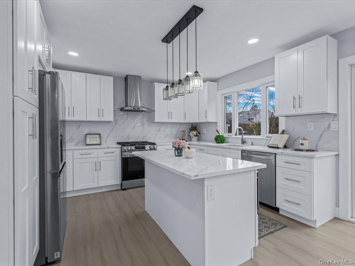 62 Essex Road Great Neck, NY 11023 - Photo 8 of 25 a kitchen with a white cabinets and stainless steel appliances