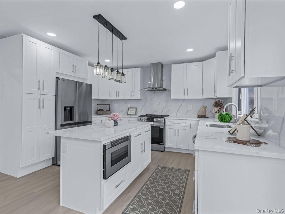62 Essex Road Great Neck, NY 11023 - Photo 9 of 25 a kitchen with a stove a sink and a refrigerator