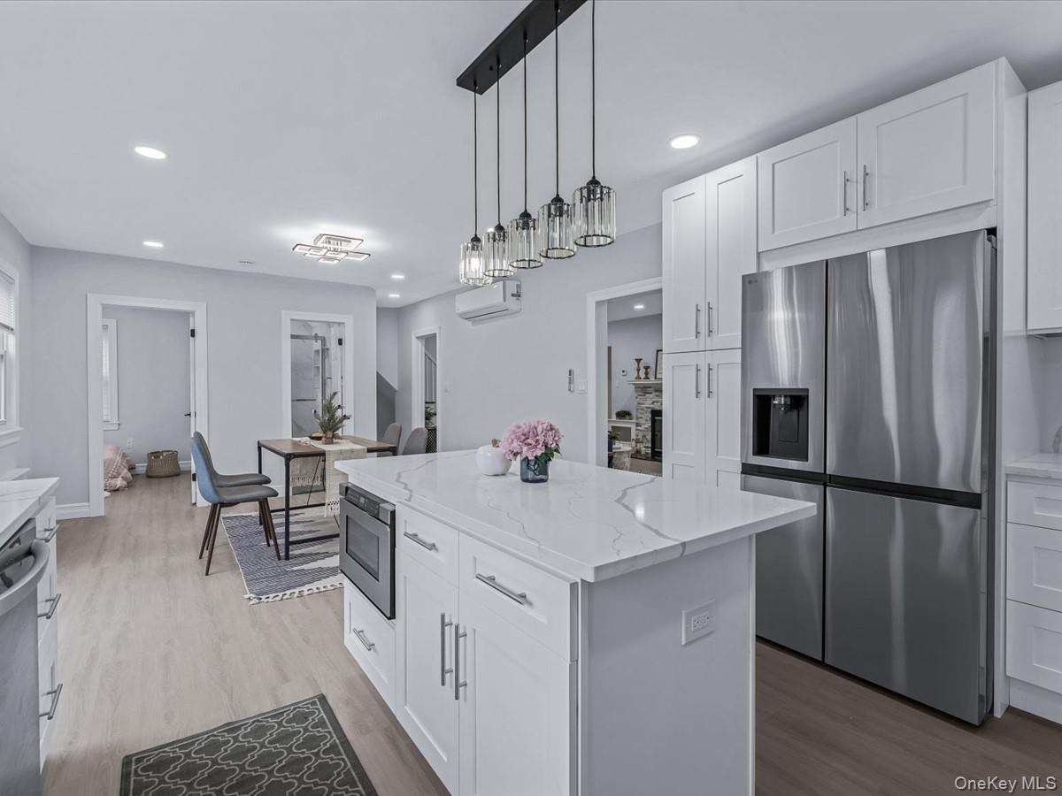 62 Essex Road Great Neck, NY 11023 - Photo 10 of 25 a kitchen with stainless steel appliances a refrigerator and a dining table