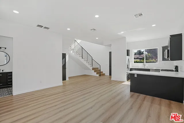 a view of kitchen with stainless steel appliances granite countertop refrigerator oven and stove with wooden floor