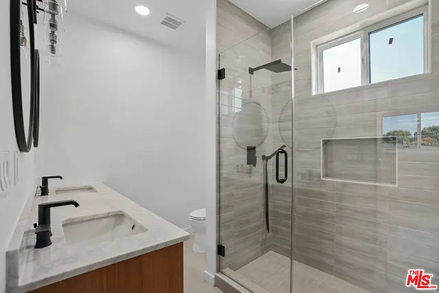 a bathroom with a shower sink and mirror