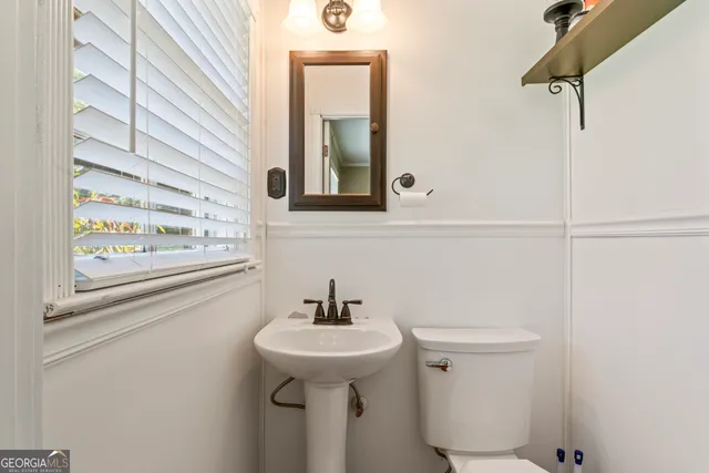 a bathroom with a sink and mirror with toilet