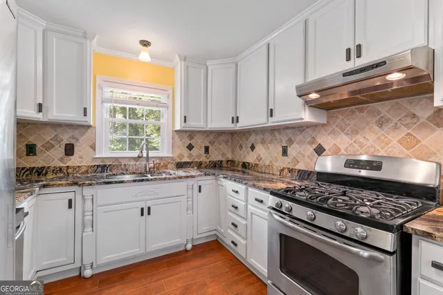 a kitchen with granite countertop a stove and a sink
