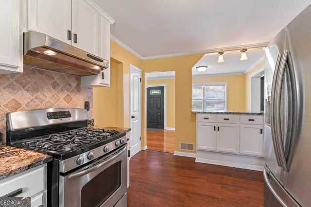 a kitchen with stainless steel appliances granite countertop a stove and a refrigerator