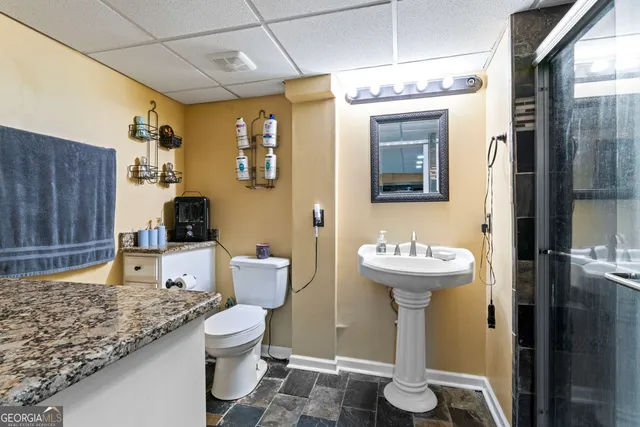a bathroom with a sink a toilet and shower