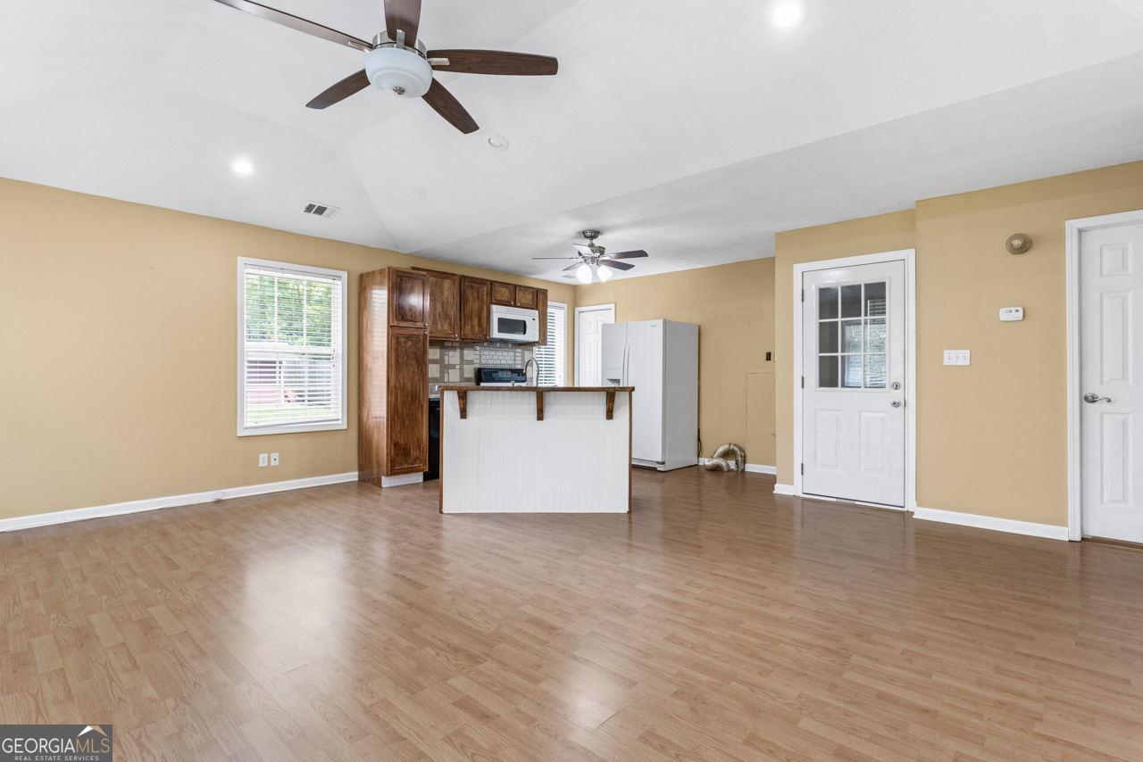 515 Valley Hill Road Stockbridge, GA 30281 - Photo 34 of 44 a view of a kitchen with a refrigerator a ceiling fan and wooden floor