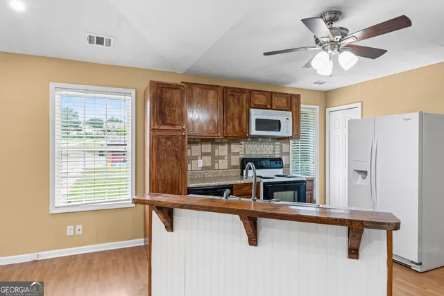 a view of kitchen with furniture and a ceiling fan