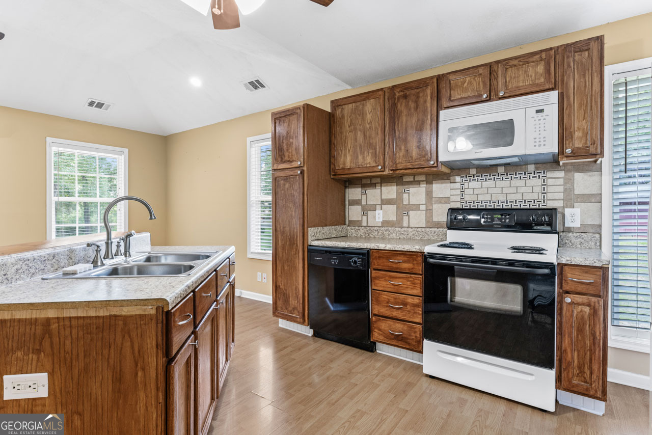 515 Valley Hill Road Stockbridge, GA 30281 - Photo 38 of 44 a kitchen with stainless steel appliances granite countertop a stove a sink dishwasher and a refrigerator