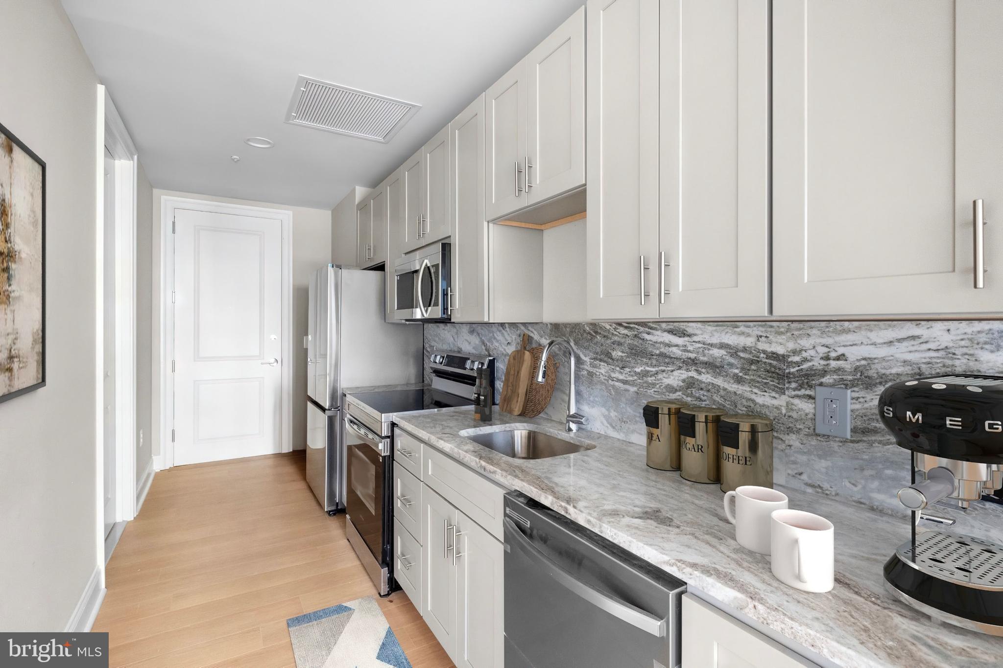 2301-61 John F Kennedy Boulevard, Unit 1512 Philadelphia, PA 19103 - Photo 17 of 39 a kitchen with stainless steel appliances granite countertop a sink stove and refrigerator
