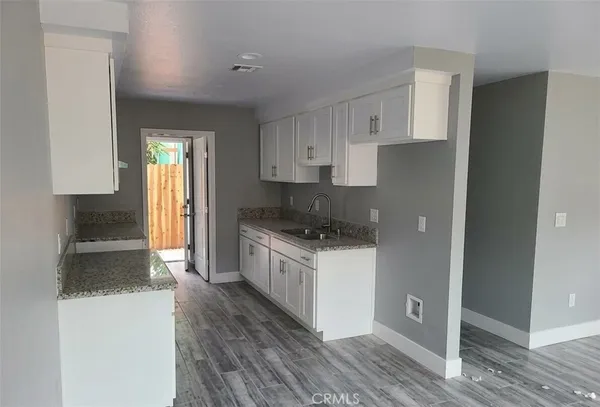a kitchen with granite countertop a refrigerator and a stove top oven