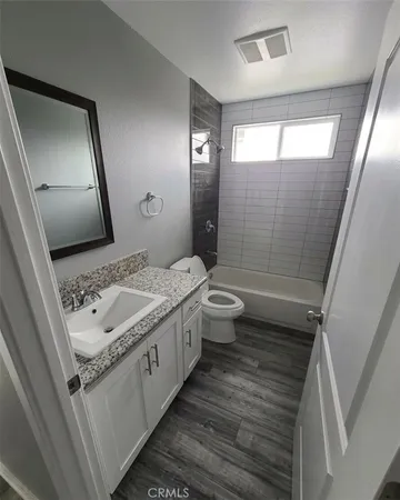 a bathroom with a granite countertop sink toilet and shower