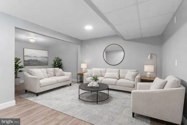 a living room with furniture a mirror and a lamp