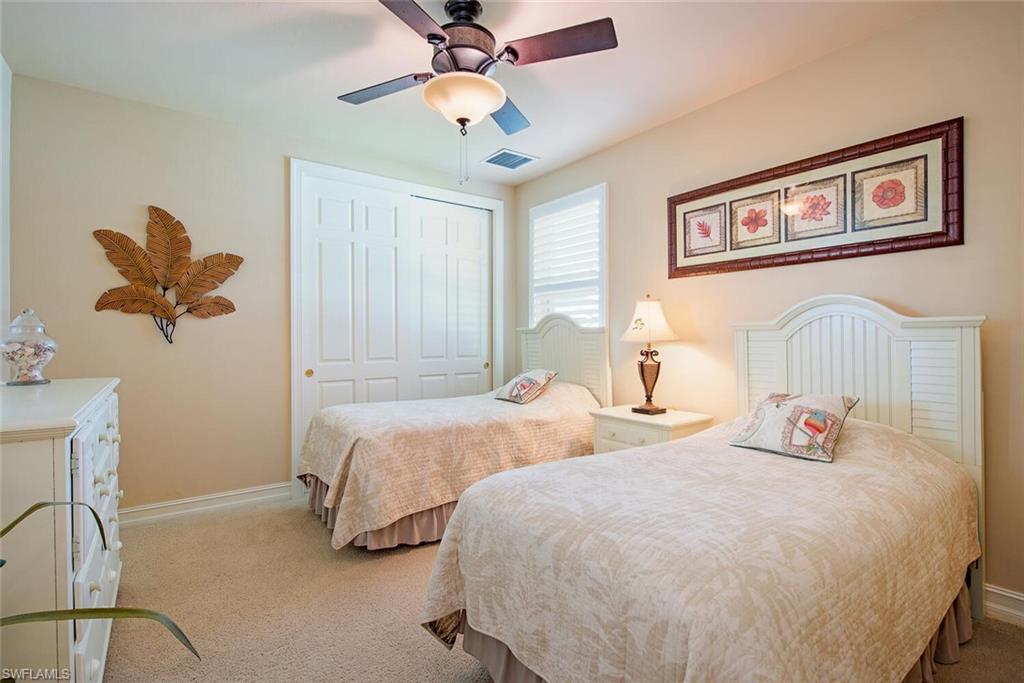 1448 Marlin Drive Naples, FL 34102 - Photo 18 of 23 a bedroom with 2 bed and a chandelier