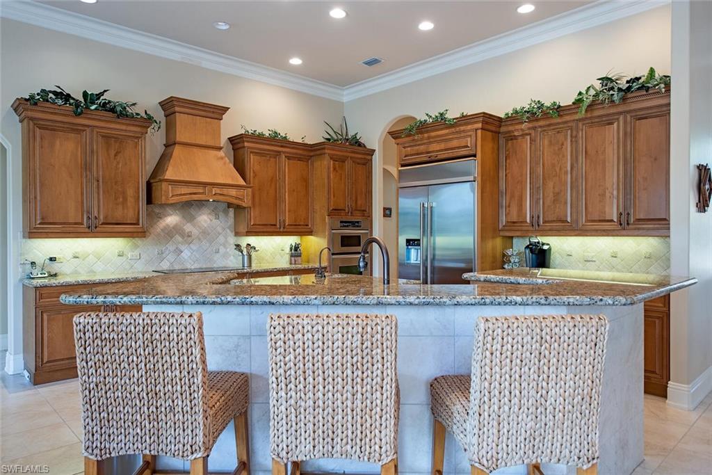 1448 Marlin Drive Naples, FL 34102 - Photo 6 of 23 a kitchen with granite countertop a stove and cabinets