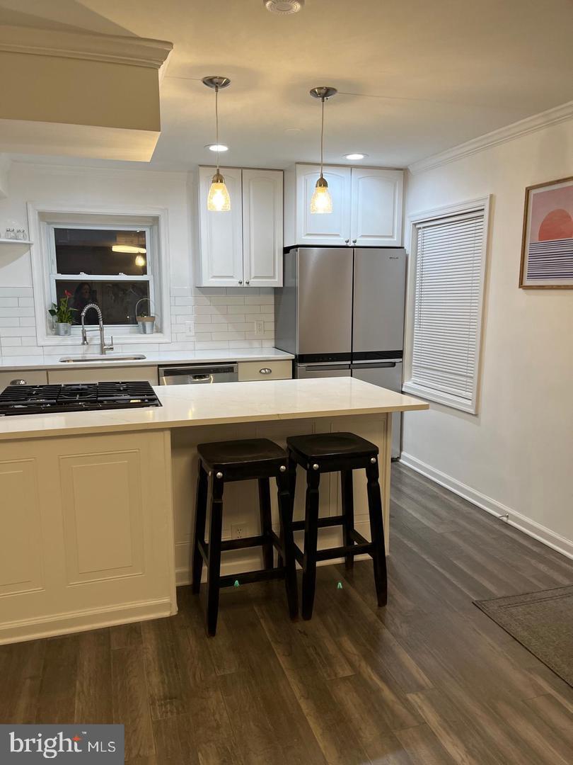 1077 South Edison Street Arlington, VA 22204 - Photo 4 of 29 a kitchen with a table chairs refrigerator and microwave