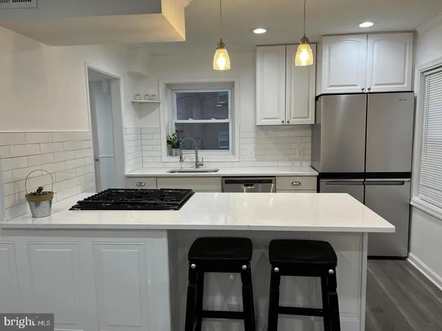 a kitchen with a table chairs refrigerator and microwave