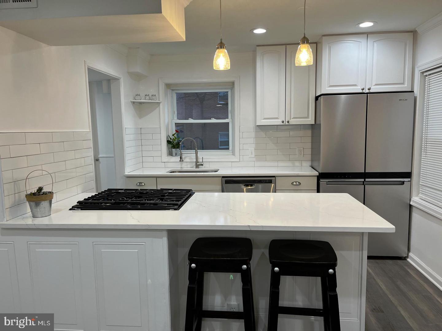 1077 South Edison Street Arlington, VA 22204 - Photo 5 of 29 a kitchen with a table chairs refrigerator and microwave