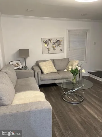 a living room with furniture potted plant and white walls