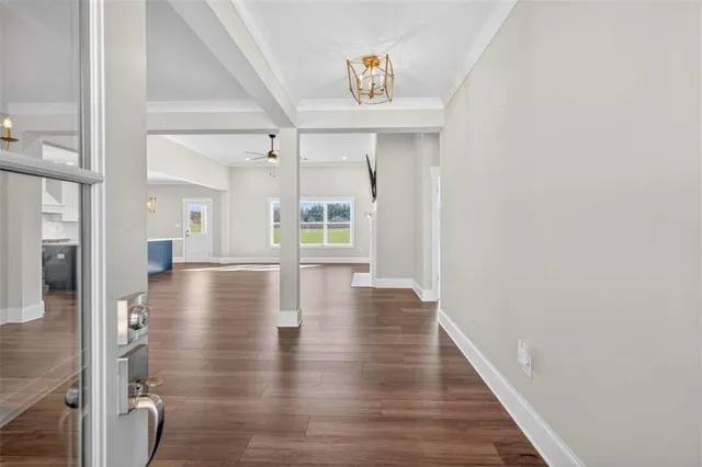 a view of a dining room and livingroom with furniture wooden floor a rug a flat screen tv a painting and a chandelier