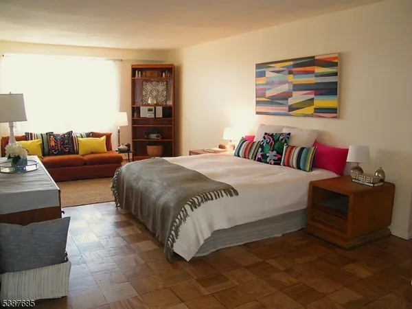 a spacious bedroom with a bed and dresser