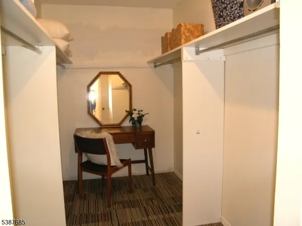 a view of a hallway with wooden floor and a dining table