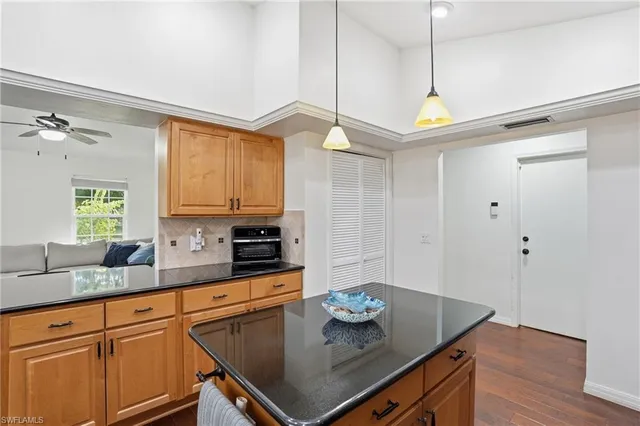 a kitchen with stainless steel appliances granite countertop a sink a stove cabinets and wooden floor