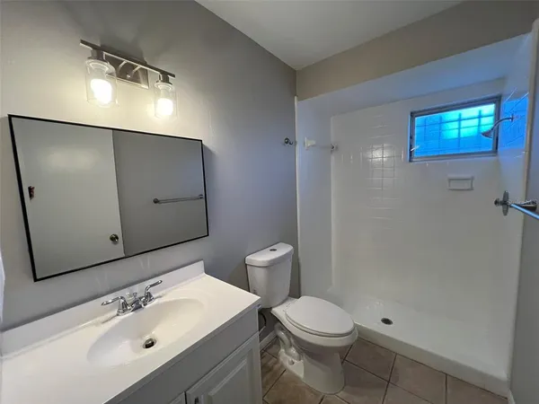 an empty room with ceiling fan and window