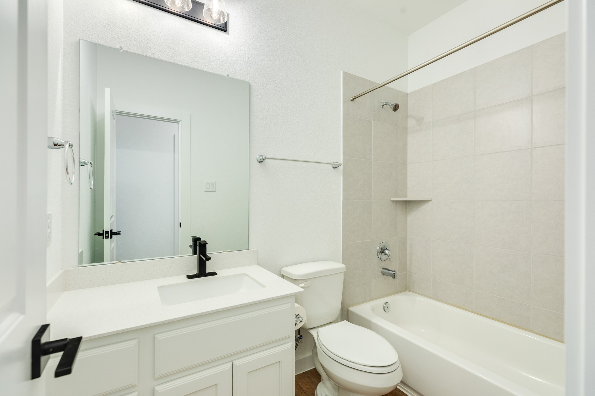 3806 Shackleton Court Rosharon, TX 77583 - Photo 11 of 50 Guest bathroom featuring a quartz countertop, black hardware, and a tub/shower combination.