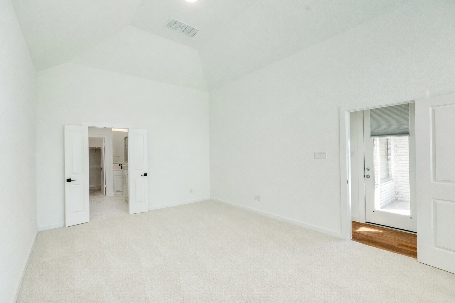 3806 Shackleton Court Rosharon, TX 77583 - Photo 24 of 50 Primary bedroom with entrance on the right, back door across the hallway, and double doors leading to the primary bath. The room features tall ceilings, recessed lighting, and carpet in excellent condition.