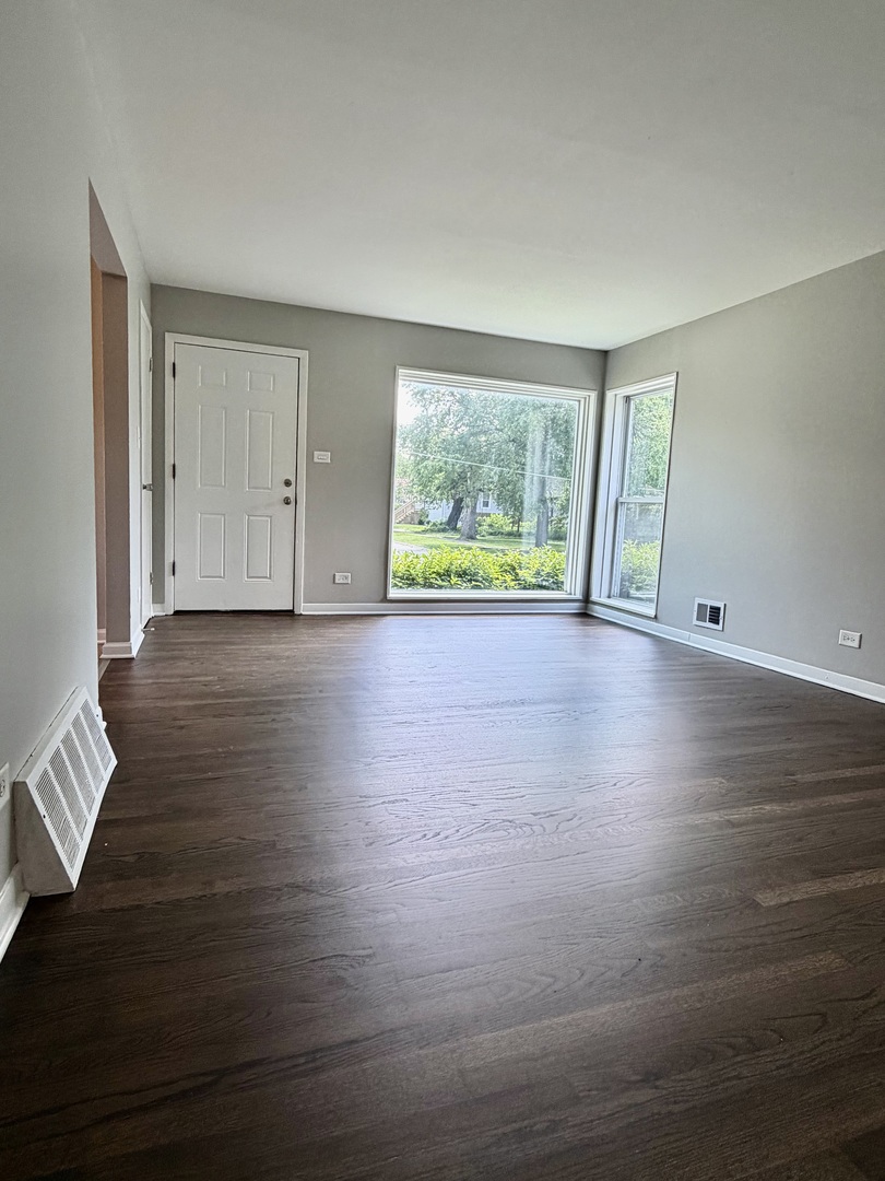 1820 169th Street Hazel Crest, IL 60429 - Photo 5 of 23 a view of an empty room with wooden floor and a window