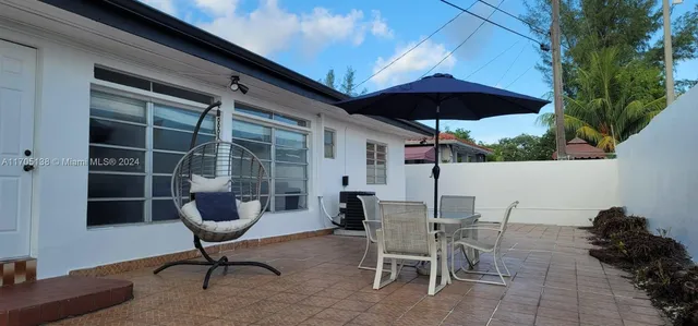a backyard of a house with table and chairs