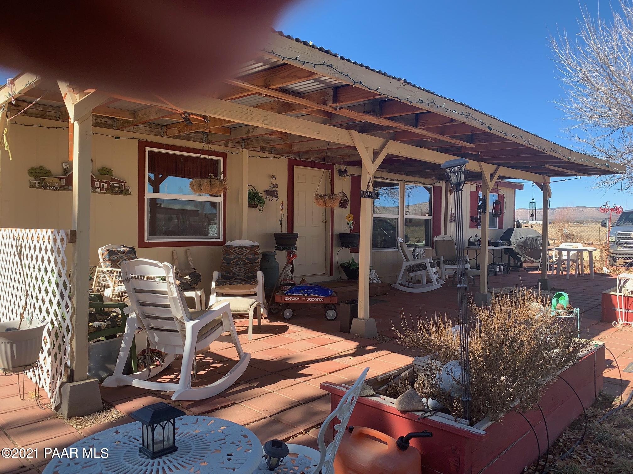 25360 North High Desert Road Paulden, AZ 86334 - Photo 1 of 16 a view of a patio with table and chairs potted plants and floor to ceiling window