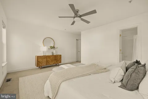 a bedroom with a bed and a ceiling fan