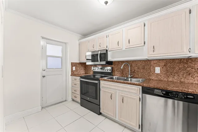 a kitchen with granite countertop white cabinets and stainless steel appliances