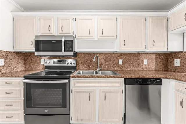 a kitchen with granite countertop white cabinets and stainless steel appliances