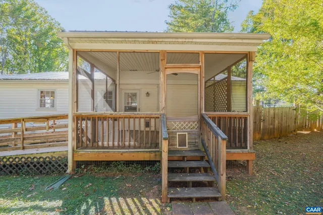 a view of a wooden house with a large window and wooden fence