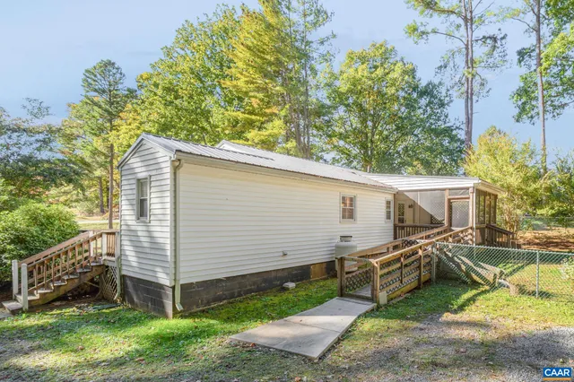 a view of a swimming pool with a yard and large trees
