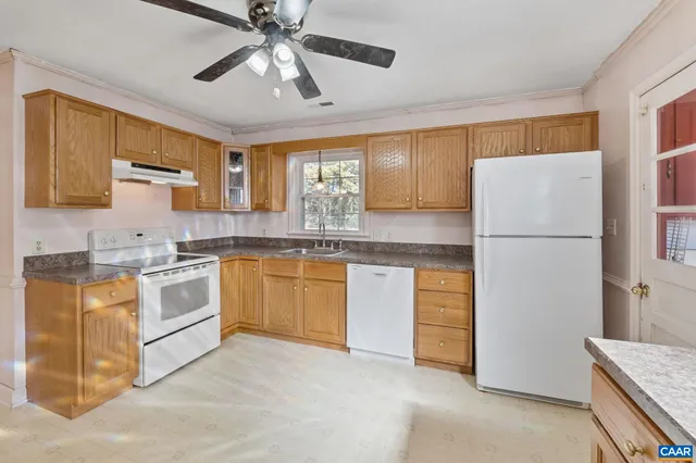 a kitchen with stainless steel appliances granite countertop a refrigerator a sink a stove and white cabinets