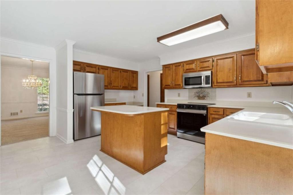 3083 Callie Still Road Lawrenceville, GA 30045 - Photo 27 of 73 a kitchen with kitchen island a counter top space a sink stainless steel appliances and cabinets