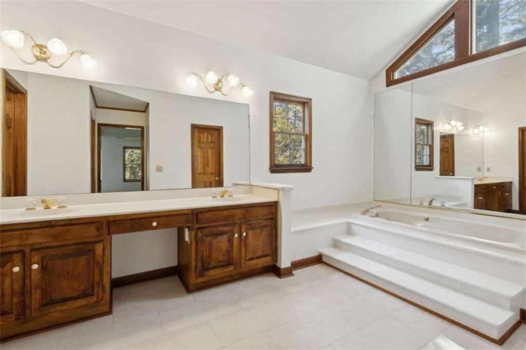 3083 Callie Still Road Lawrenceville, GA 30045 - Photo 41 of 73 a spacious bathroom with a double vanity sink large mirror and bathtub