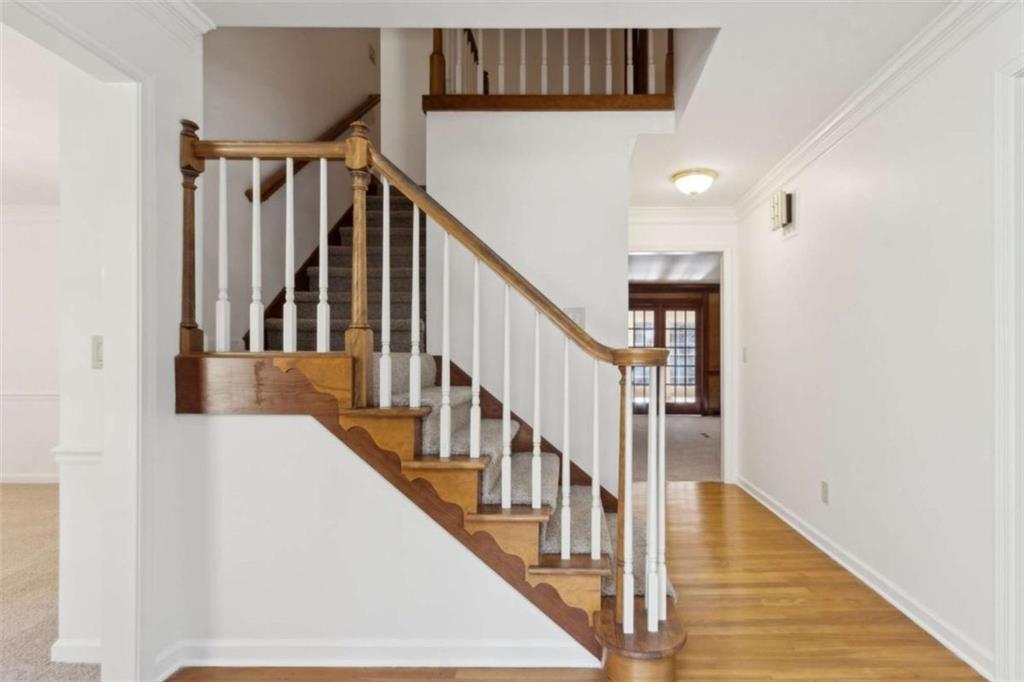 3083 Callie Still Road Lawrenceville, GA 30045 - Photo 6 of 73 a view of staircase with lots of frames on wall and wooden floor