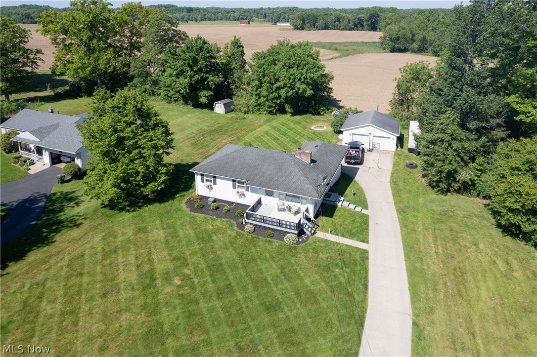 3659 Morrow Road Kent, OH 44240 - Photo 38 of 39 Expansive property featuring a white residence with a dark roof, a two-car detached garage, a long paved driveway, and established landscaping