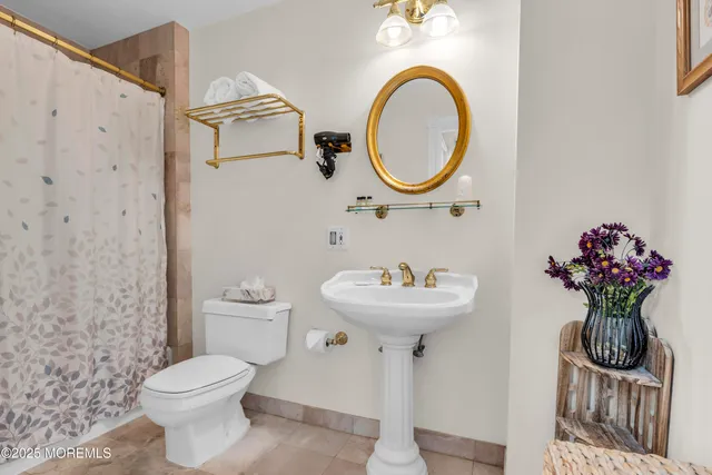 a bathroom with a sink mirror toilet and a shower