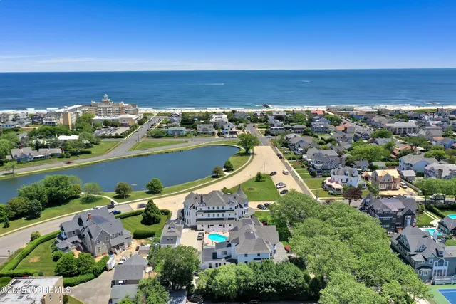 an aerial view of ocean and residential houses with outdoor space