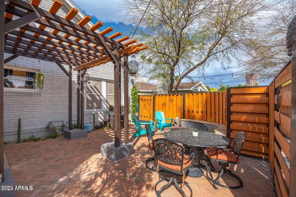 525 West Granada Road Phoenix, AZ 85003 - Photo 19 of 26 a view of patio with a table and chairs under an umbrella with wooden fence